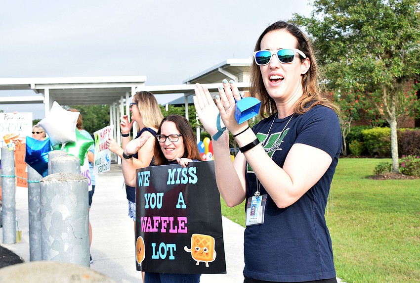 Robert E. Willis Elementary School teachers Brittany Alecia and Kaitlyn Miller cheer for students as they come through the parade.
