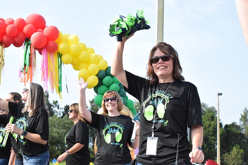 Robert E. Willis Elementary School fifth grade teacher Denise Herrera and Principal Kathy Price cheer for students as they finish the parade.