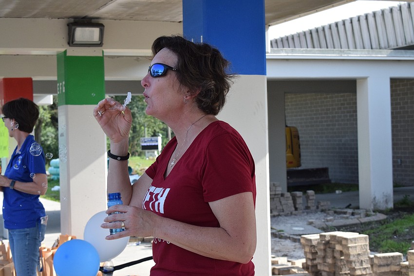 Laura Schuneman, a fifth grade teacher at Gene Witt Elementary, blows bubbles during a fifth grade farewell parade.