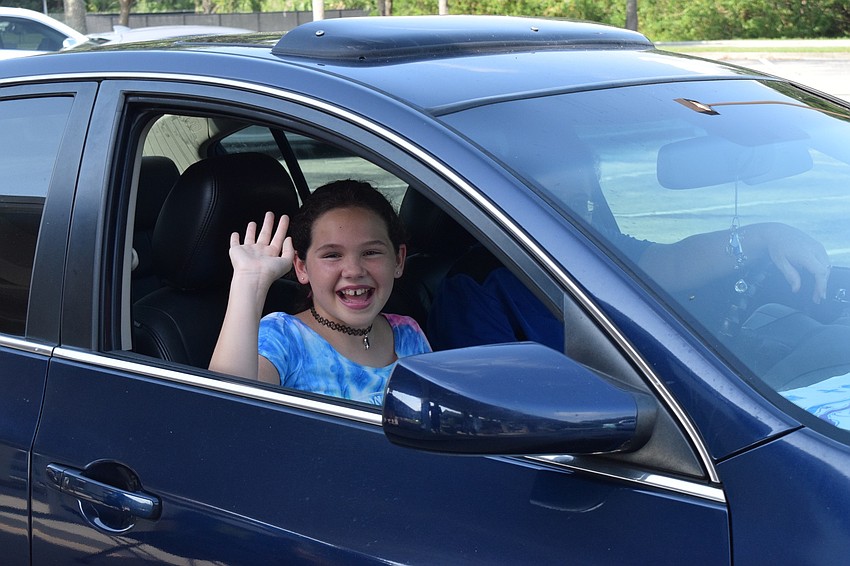 Sara Green, a fifth grader at Gene Witt Elementary, waves goodbye to her teachers.