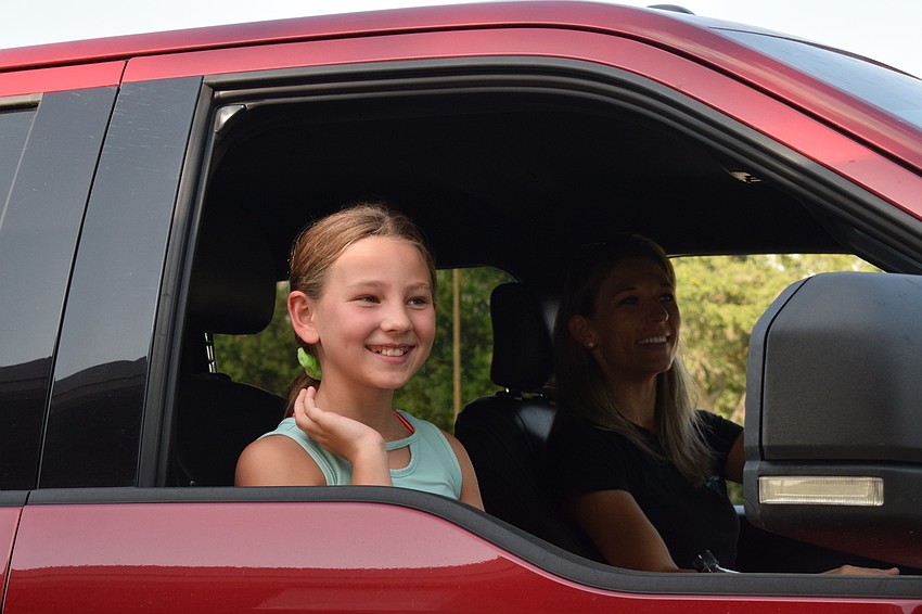 Ryleigh Baker, a fifth grader at Gene Witt Elementary School, waves as she sees her teachers.