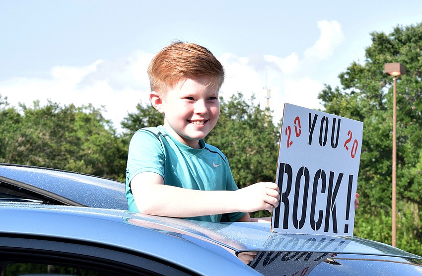 Declan Arnold, a fifth grader at Gene Witt Elementary, decorates his car with signs for his teachers.