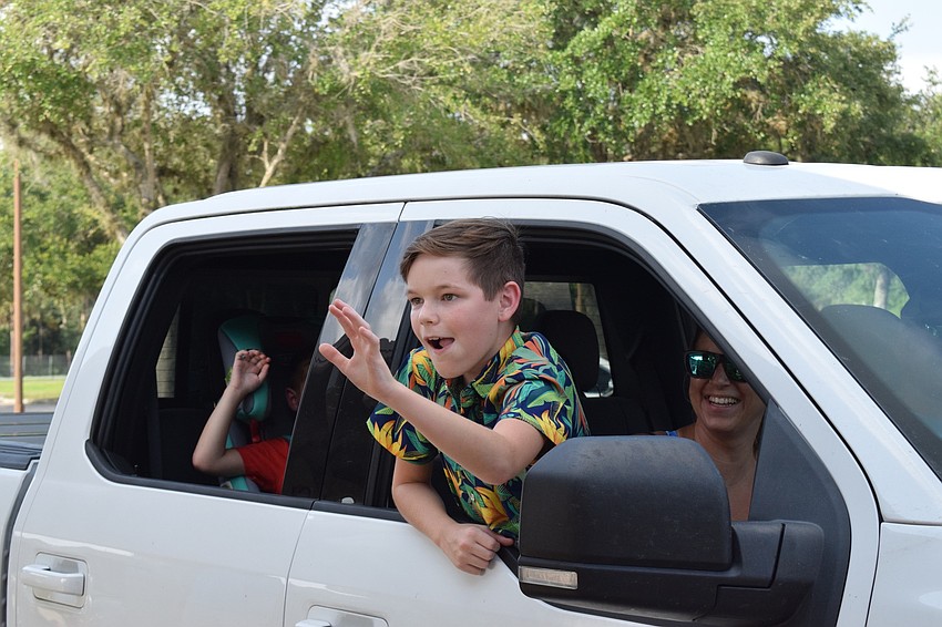 Caleb Smith, a fifth grader at Gene Witt Elementary School, waves goodbye to his teachers. Debbie Pope, a teacher aide, says he was sweet and quiet in class.
