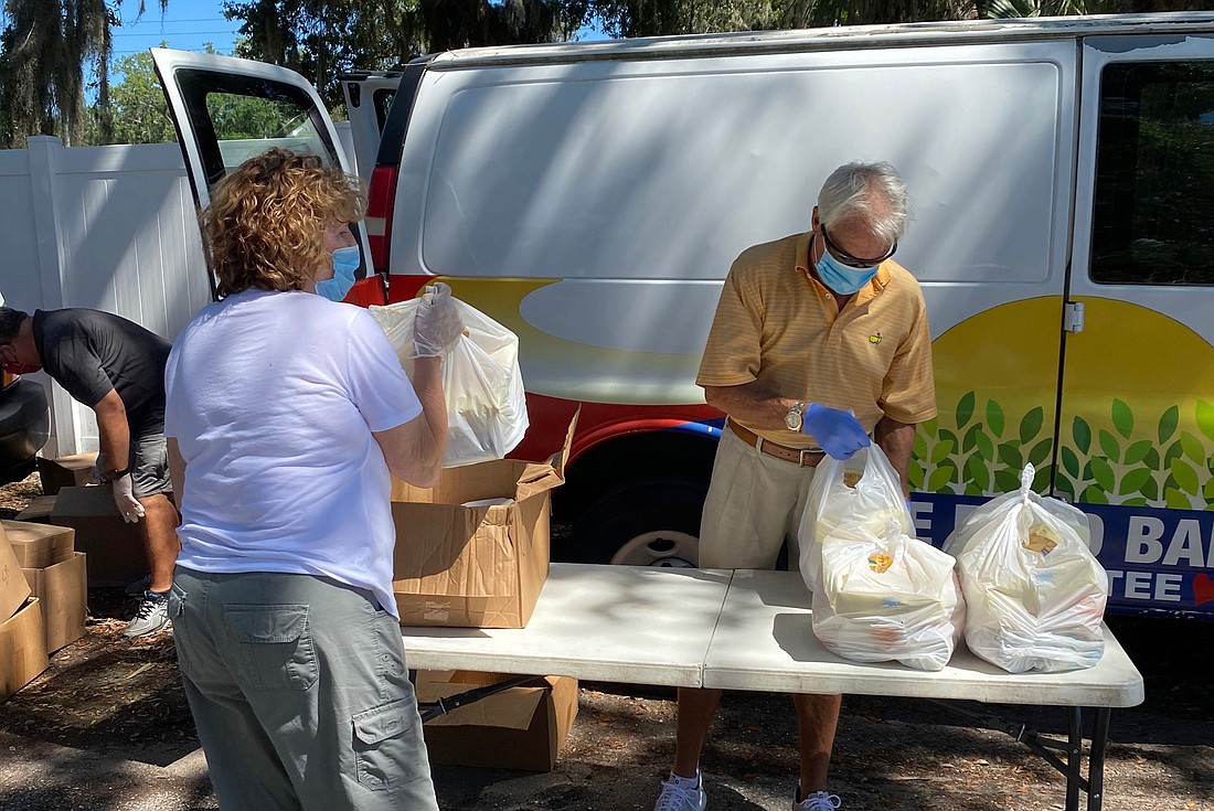 Charlene Moran and Mark Goodness package food for Meals on Wheels Plus of Manatee to distribute. The nonprofit is having another distribution and collection event at Ellenton Premium Outlets Saturday. Courtesy photo.