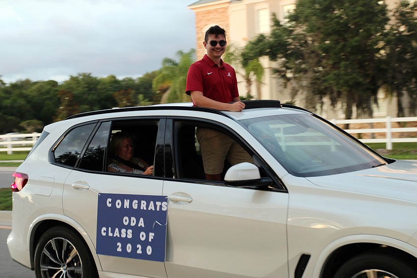 Senior Connor Cintron attends the Class of 2020 parade that goes down Deer Drive. Out-of-Door Academy posted large photos of the seniors along the sidewalk. Courtesy photo.