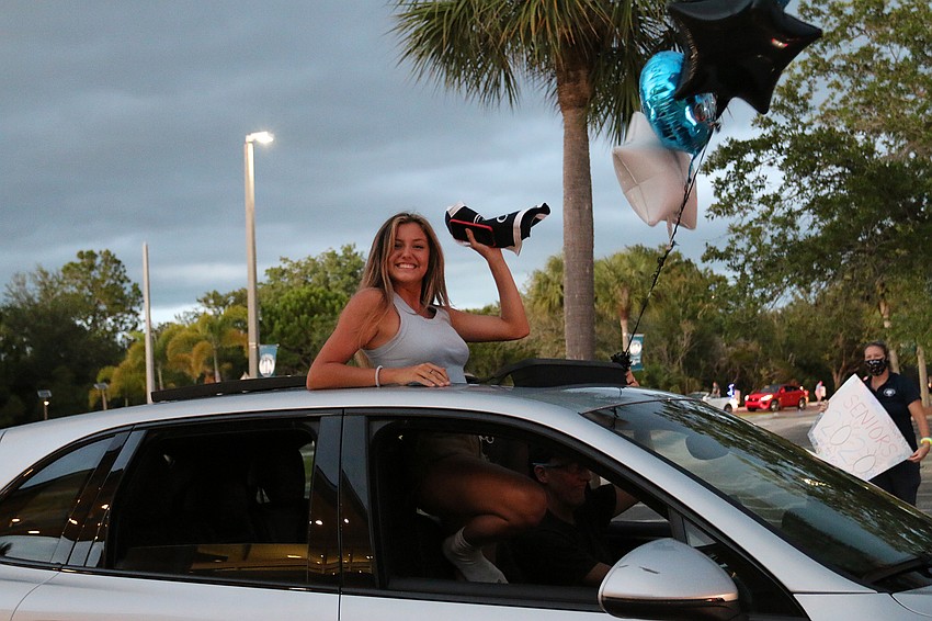 Senior Elle LaClair waves to teachers and staff members as she goes through the parade. Courtesy photo.