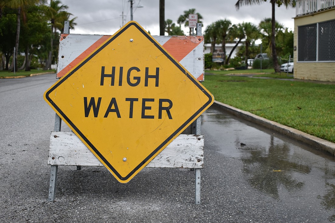 A sign warns drivers of high water on Saturday afternoon in the Longbeach Village neighborhood of Longboat Key.