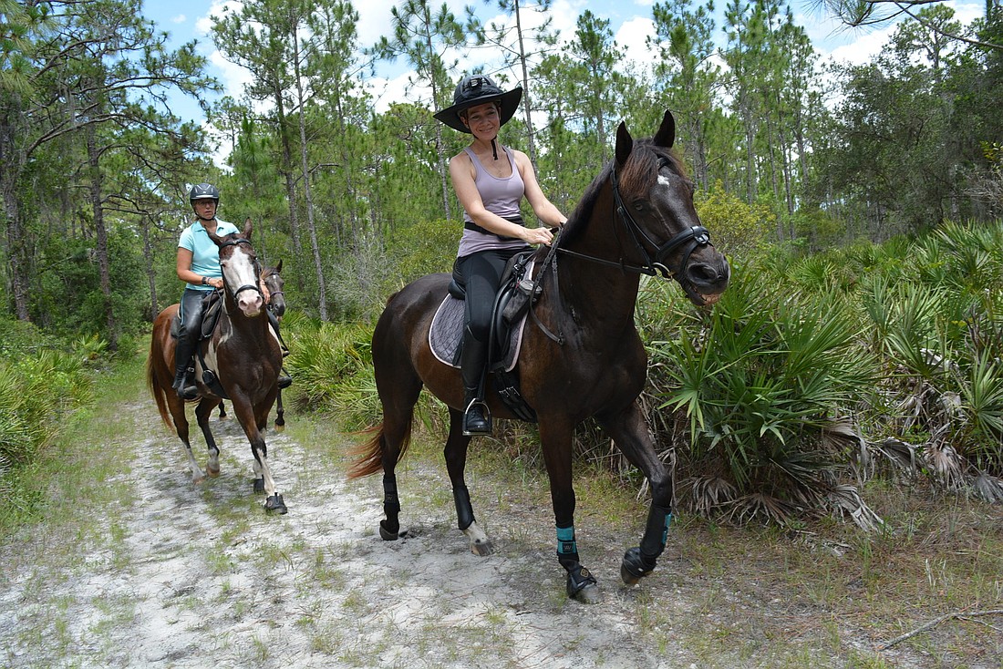 Panther Ridge&#39;s Olga Ways, on Phillipe, rides through a trail. She and other equestrians can ride more than 14 miles of continuous trails. "We definitely moved here because of the equestrian trains and the length of the trails," s