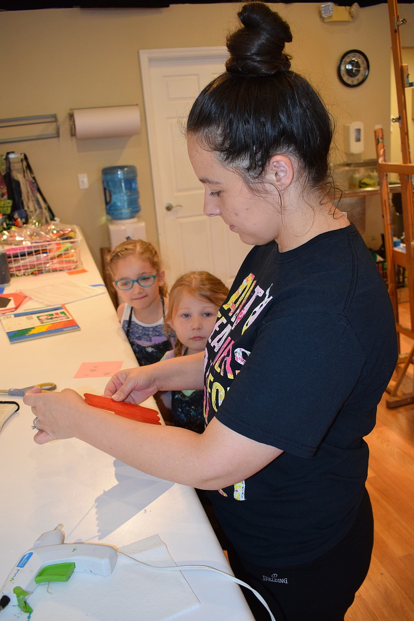 Let's Create Art's Whitney Vance puts the finishing touch on her students' projects.