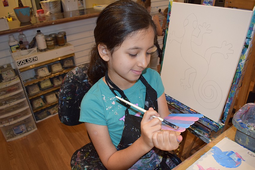 East County 7-year-old Lorena Lopez carefully paints her project.