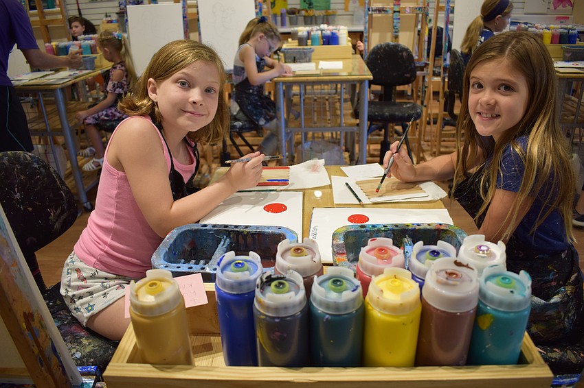 Lakewood Ranch 8-year-old Aubrey Truman and Parrish 9-year-old Maddison Butz have plenty of supplies available as they paint for their dads, Dan Truman and Jon Butz.