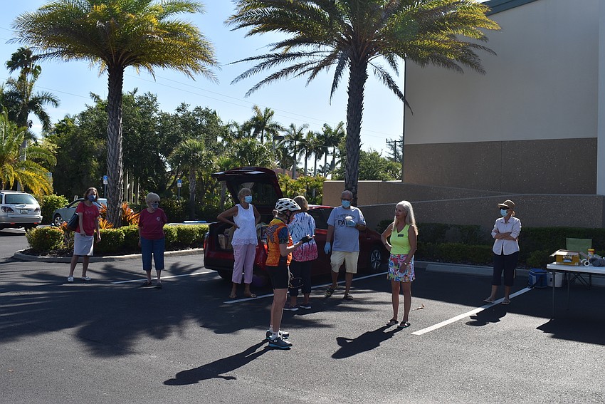 Members gathered in the parking lot to catch up amid the food drive.
