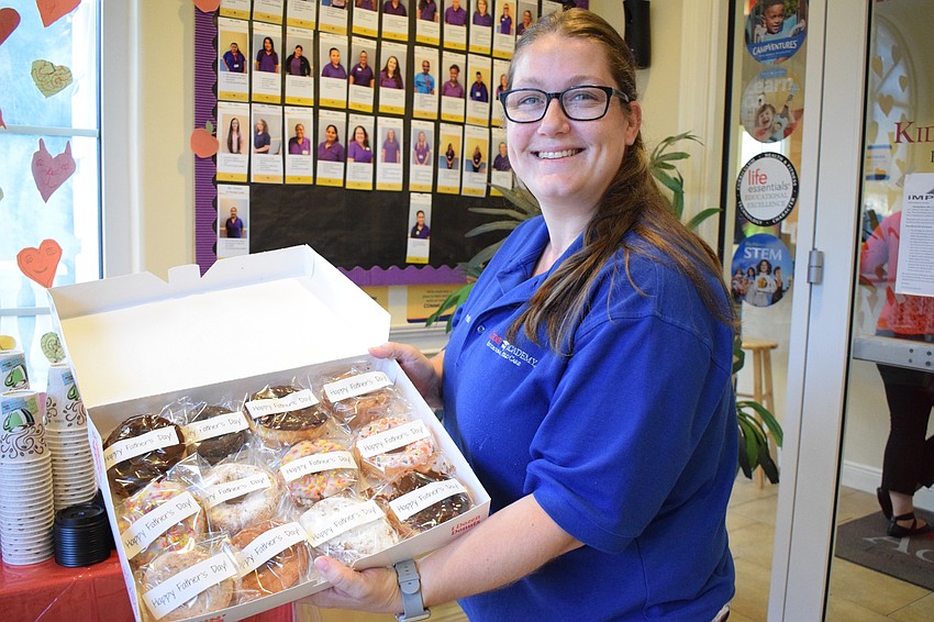 Brooke Williams, assistant director at Kiddie Academy, sets up the table for Donuts with Dad.