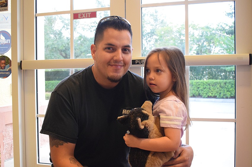 Cameron Allen hugs his 4-year-old daughter Addison before sending her off to class.