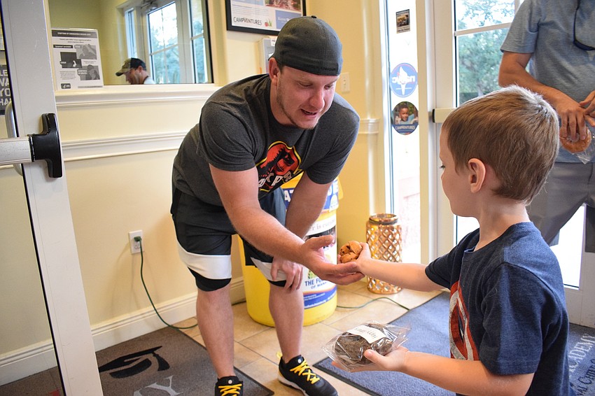 Justin Wisniewski laughs as his 4-year-old son Aiden gives him mini muffins instead of the donut Kiddie Academy was giving fathers to celebrate Father's Day.