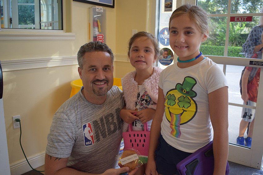 Bryan Sharp says goodbye to his daughters, Kelsey, 5, and Kendall, 8, before they go to class.