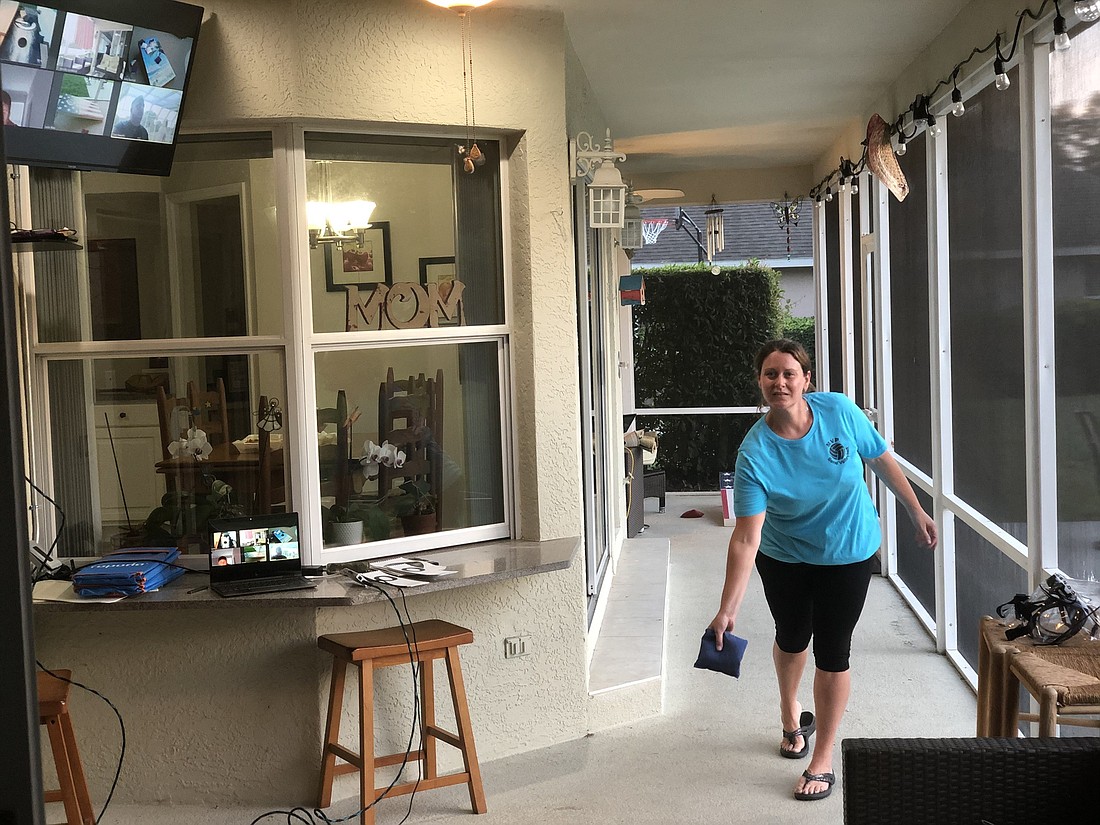 Lakewood Ranchâ€™s Jenn Lockwood and other players of virtual cornhole use two cameras to showcase their turn. One camera focuses on the throw, and the other focuses on where the beanbag lands.