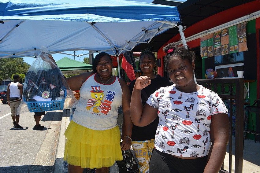 Jackie Eubanks, Meri Thomas and Lamayae Thomas pose at a tent with Father’s Day baskets for sale.