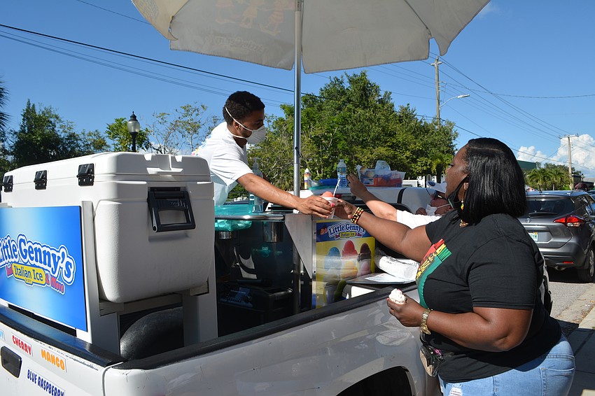 Chaniqueva Collins grabs a cup of Italian ice she purchased.