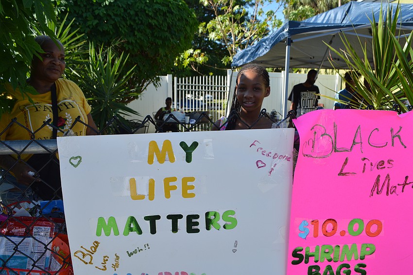 Zaiauna Middleton shows off a sign she made, posted outside of a stand where she sold candy.