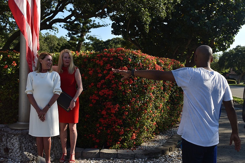 Rozance and Susan Phillips line up by the flag while Gaines directs Larson.