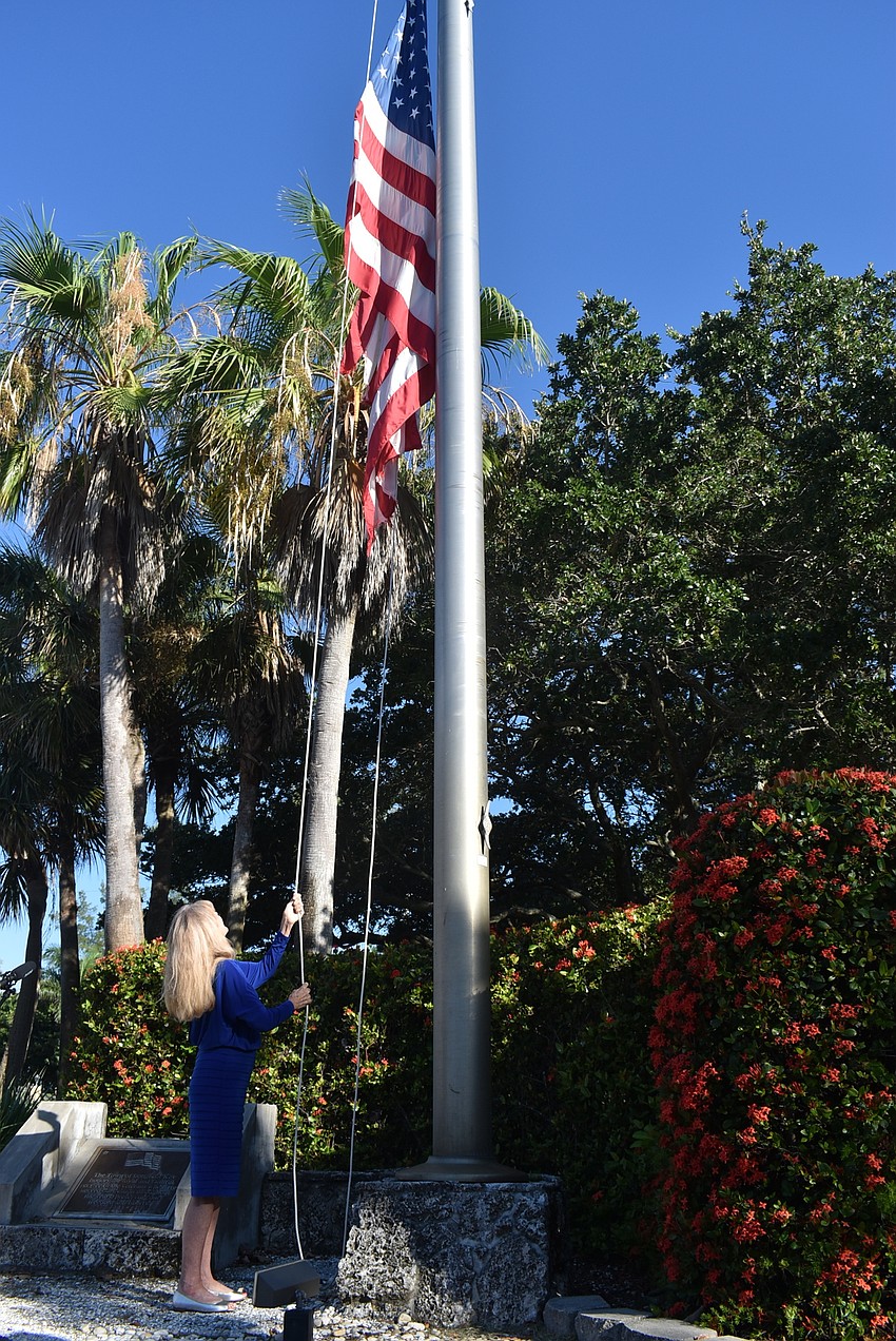 Larson begins to raise the flag.