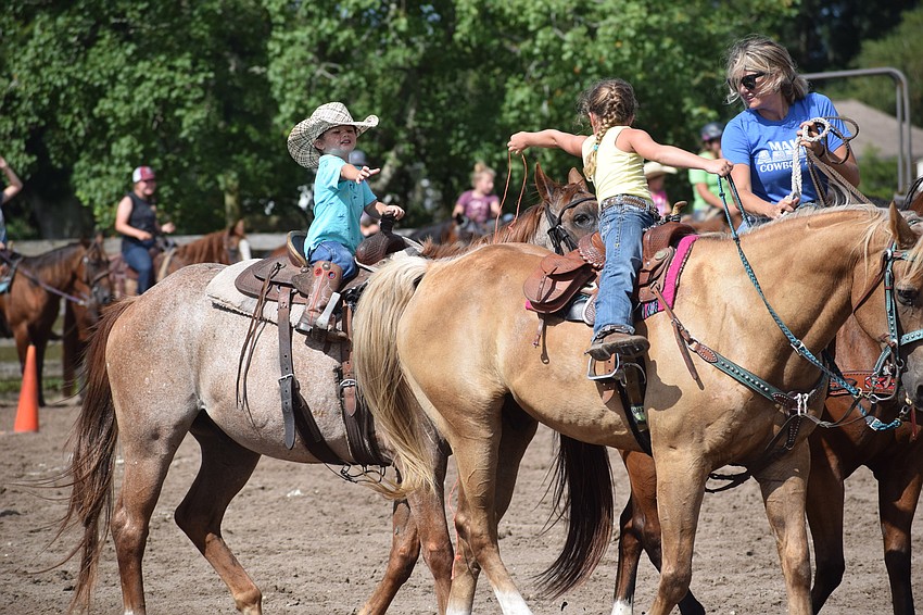 Zolfo Springs' Westin Dieter, 3, can't quite reach the string that his 5-year-old sister, Sloane, is trying to hand him. Mom Jordan Dieter leads them.