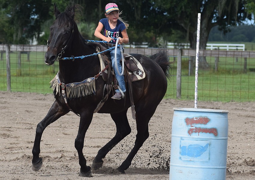 Myakka City's Chaislee Conrad, 7, circles a barrel during the relay race.