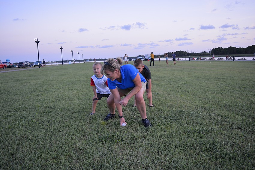East County resident Sandy Drake, deputy chief of the Longboat Key Fire Department, plays football with her friend's children, Grayson  and Colton Adams, of Venice.