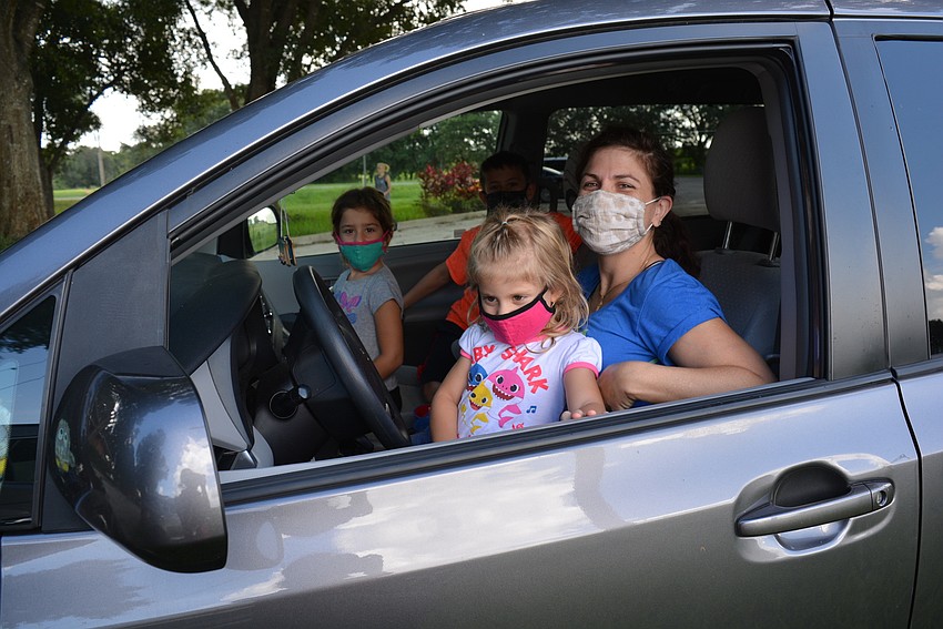 Lakewood Ranch's Agam Neeman sits in the lap of her mother, Carli Neman, as they and her siblings, Iliana and Etan, behind, watch the trick fire show.
