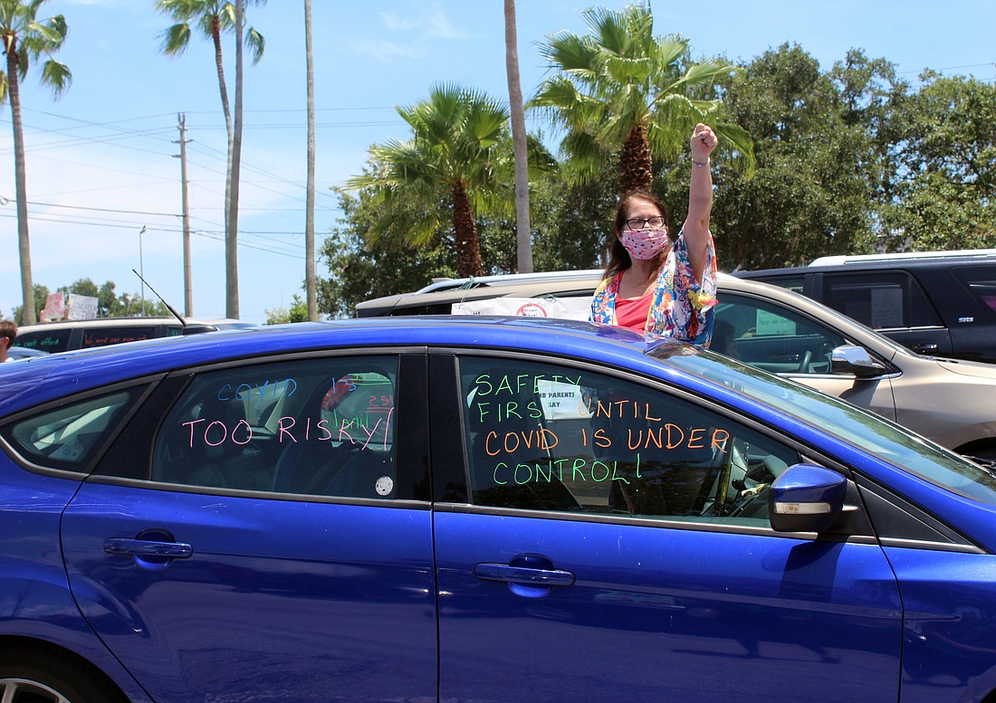 Mary Holmes honks her horn in protest of returning to schools.