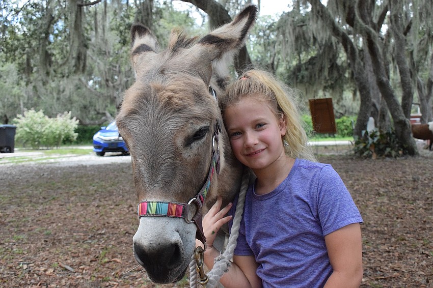 Skye Baldock, an 8-year-old camper, has been participating in the camp for five weeks, spending every week with Monster, a mini donkey.