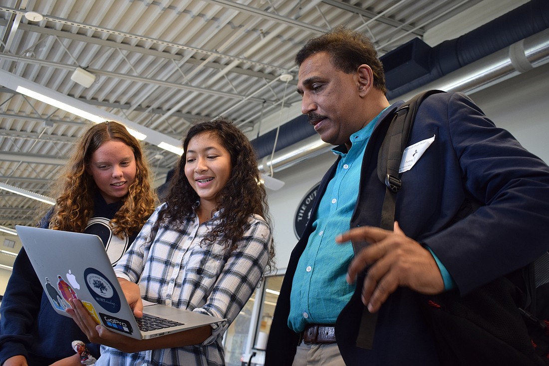 Out-of-Door Academy rising seniors Reece Whatmore and Supawadee Surattanont explain their work to address red tide with Joaquim Goes, a Columbia University professor.  Students will return for in-person classes Aug. 25. File photo
