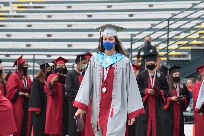Penelope Sugg makes her way across the baseball diamond with her diploma.