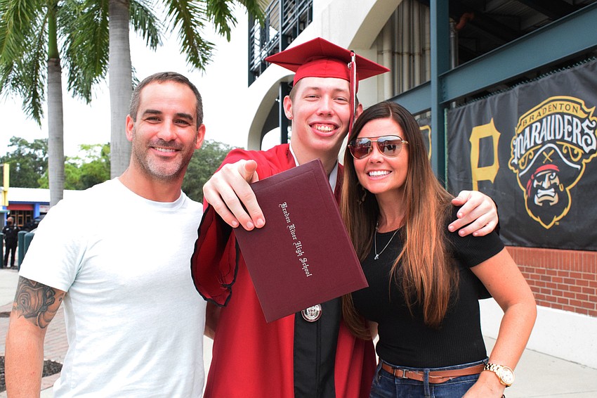 Peter Proll congratulates his stepson James Fowler on his graduation with his mother, Amanda Miller. 