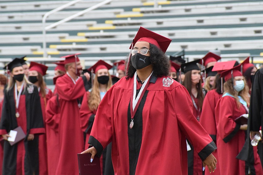 Chloe Carnegie walks across the field with her diploma.