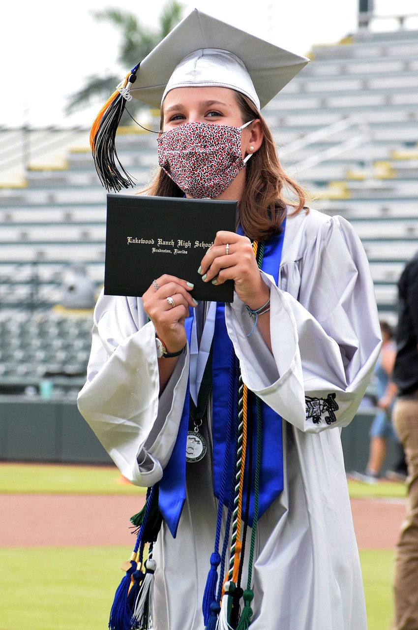 Lindsey Hyer shows off her diploma to her family in the stands.
