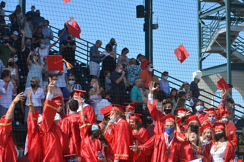 The Mooney grads throw their caps in the air as an exclamation point on their high school careers.