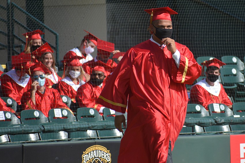 Michael Bright strides across LECOM Park's infield to receive his diploma.