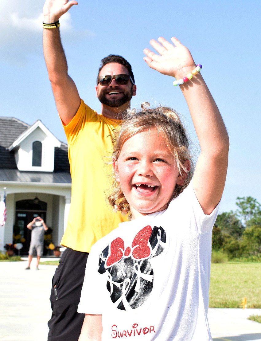 Matt and Charlotte Wells wave to family and friends as they pass in their cars.