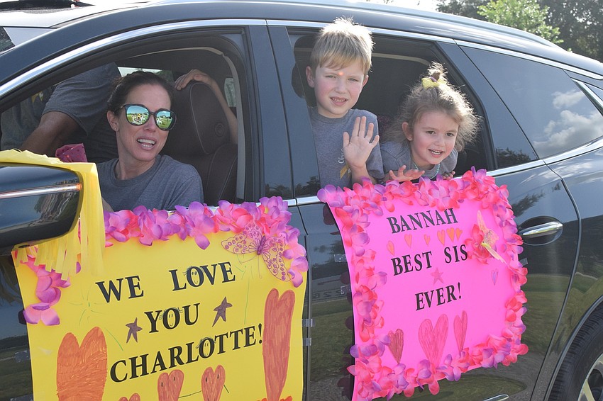 Lindsay Markun shows the signs she made with her children Mason and Olivia to celebrate Charlotte Wells' last day of chemotherapy.