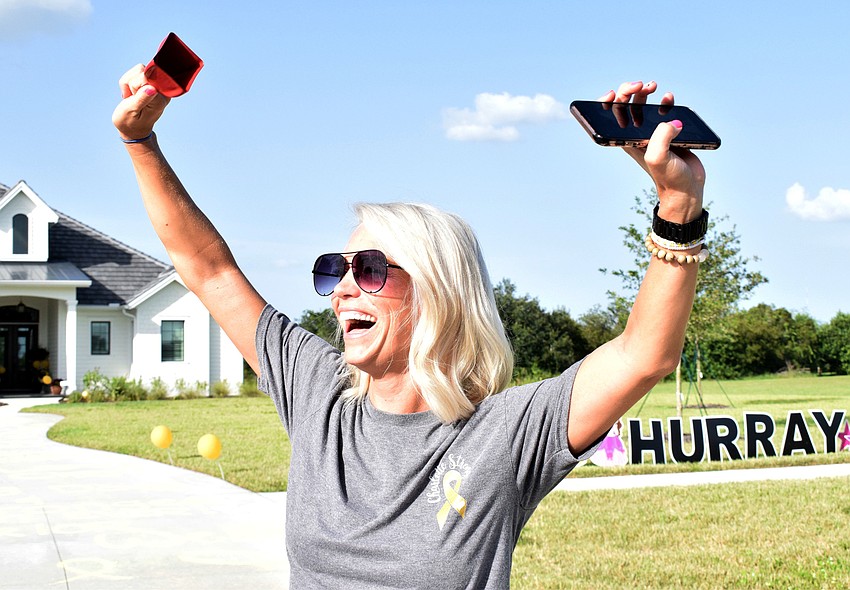Rachel Wells cheers as family and friends pass by. 