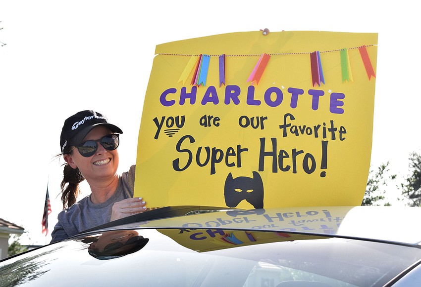 Jessica Chmielarski shows off the sign she made for Charlotte Wells, who is celebrating her last day of chemotherapy.