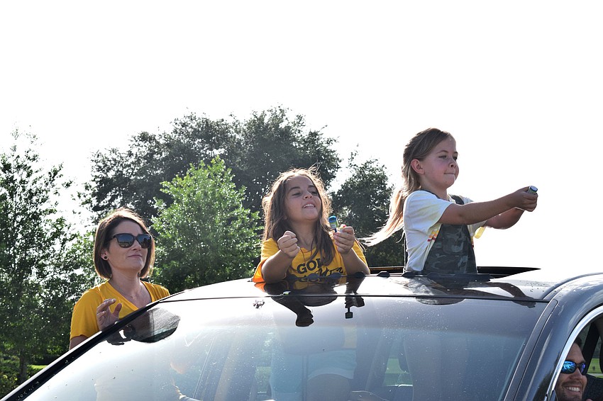 Amanda Chandler and Camryn and ReAnn Kolbe open confetti poppers.