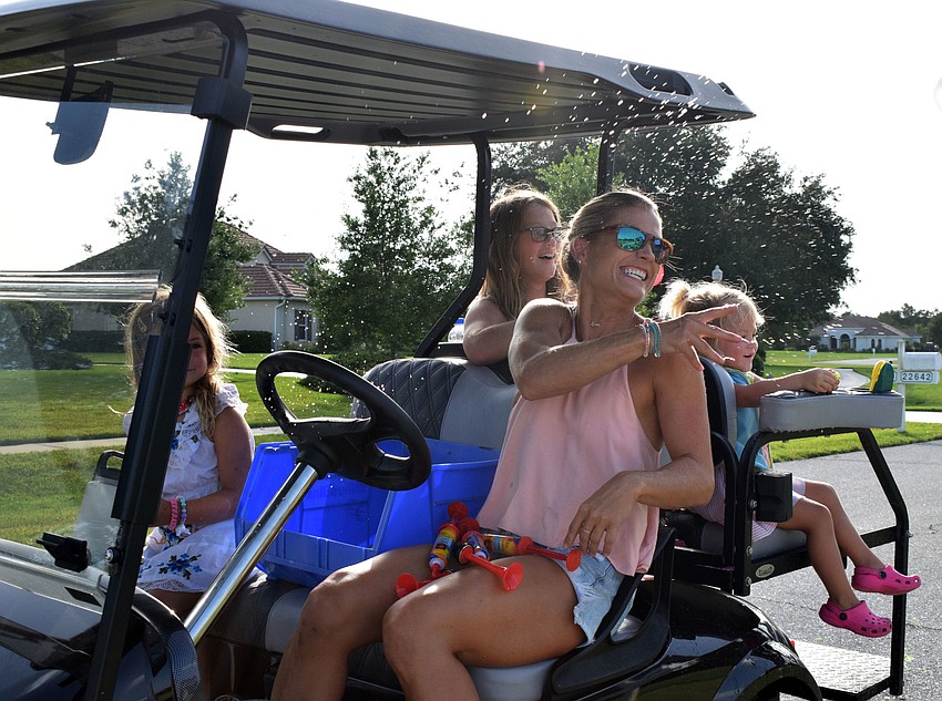 Devon, Makayla and Colby McFarland watch as their mom, Megan, throws a water balloon at Charlotte Wells.