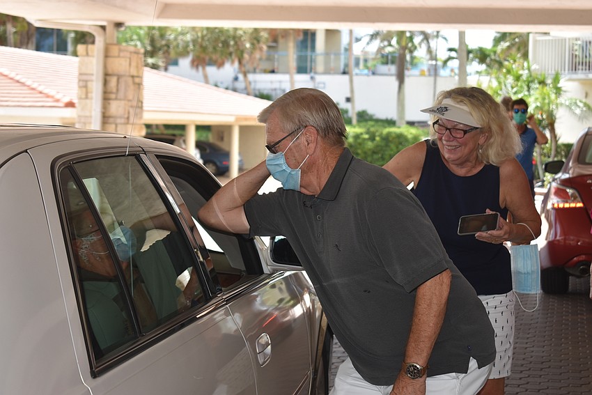 Larry Poole bumps elbows with a friend who came by to say happy birthday to Loftis.
