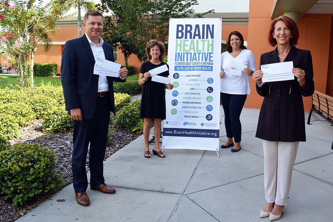 Lakewood Ranch Medical Center CEO Andy Guz, Brain Health Initiative Executive Director Stephanie Peabody, LWR Communities&#39; Monaca Onstad and County Health Officer Jennifer Bencie hold survey invitations.