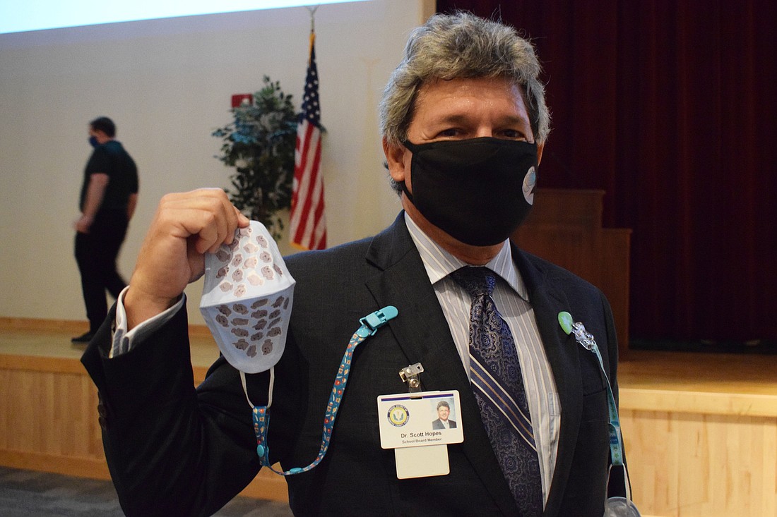 Scott Hopes, a School District of Manatee County board member, shows one of the masks that will be distributed as part of the Mask Up Manatee Coalition campaign to reduce the spread of COVID-19.