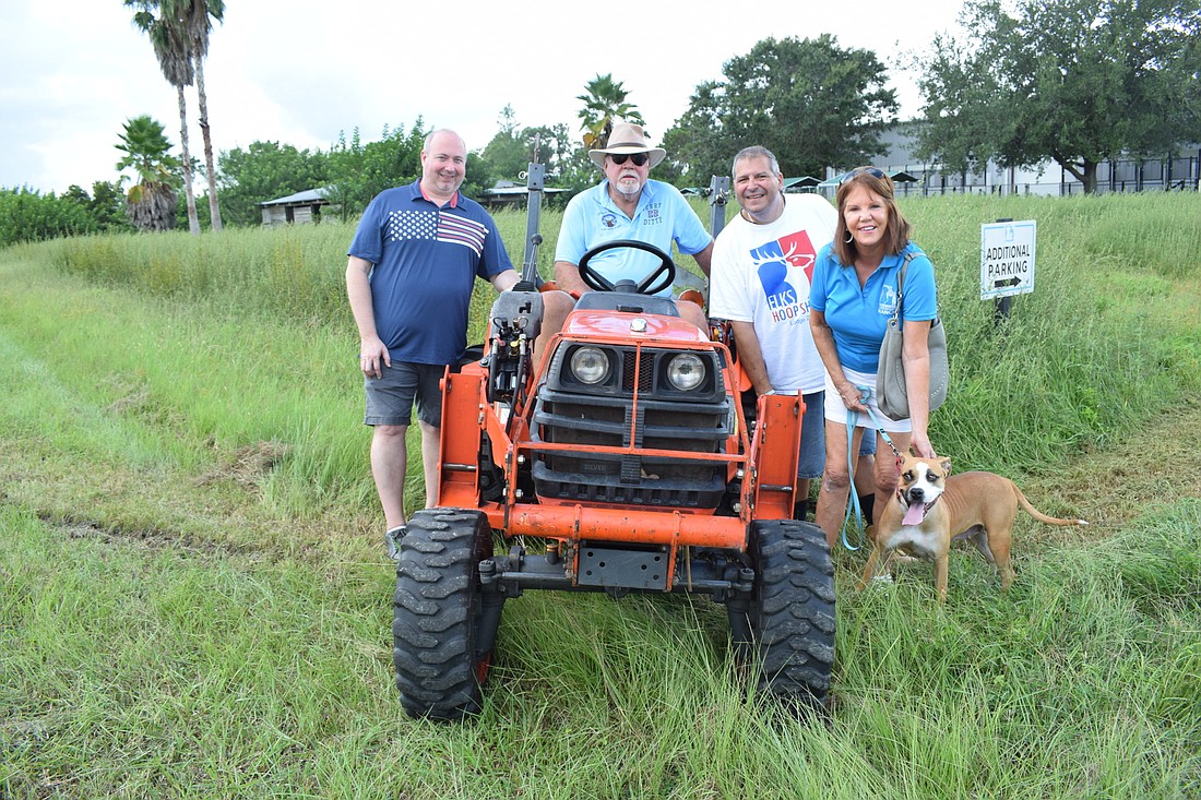 Lakewood Ranch Elks Brett Davis, Jerry Ditty and Darrin Simone join Human Society at Lakewood Ranch Treasurer Nadine Stein before the mowing begins.