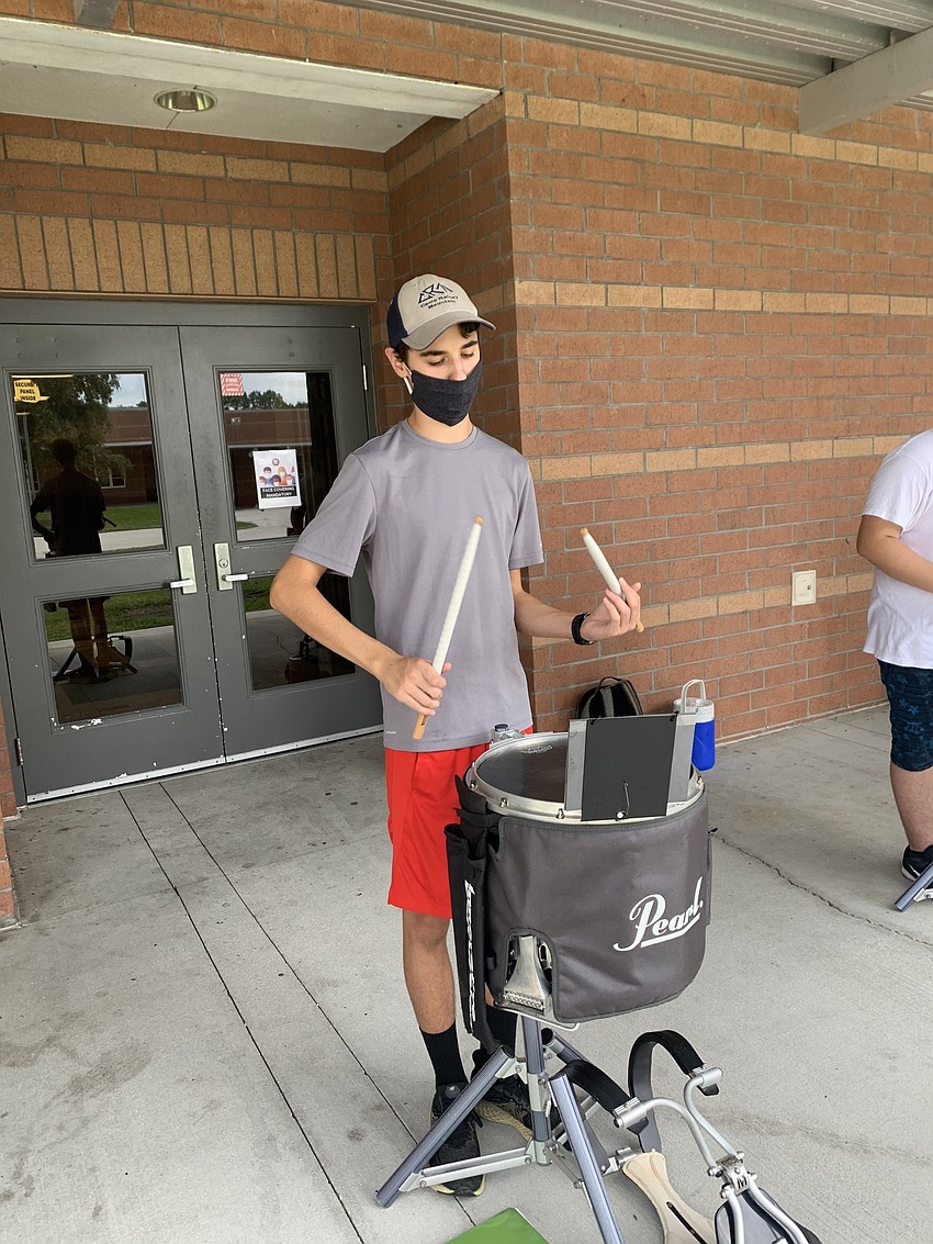 Junior JT Wright wears a mask while playing snare drums during an hourlong rehearsal. Courtesy photo.